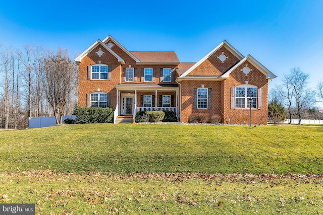 view of front of property with a front lawn, fence, covered porch, and brick siding