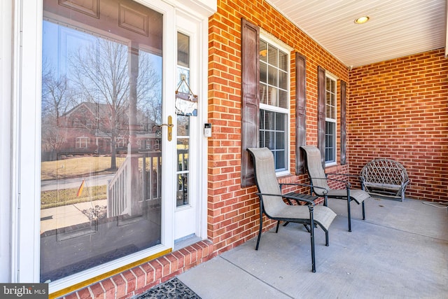 exterior space with brick siding and a porch