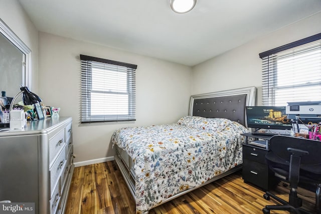 bedroom with baseboards and wood finished floors