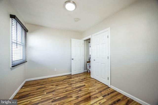 unfurnished room with baseboards and wood finished floors