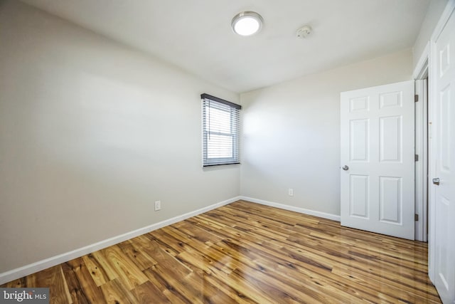 unfurnished room featuring baseboards and wood finished floors