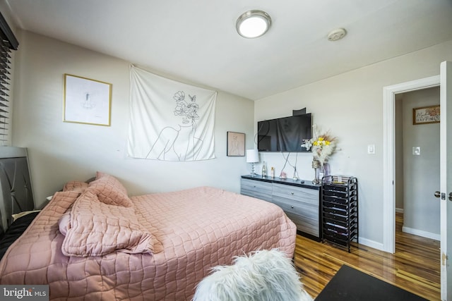 bedroom with baseboards and wood finished floors