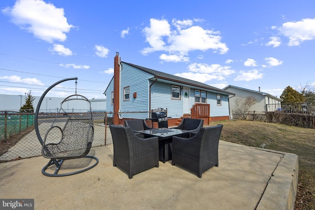 rear view of property featuring a patio, a lawn, a chimney, and fence