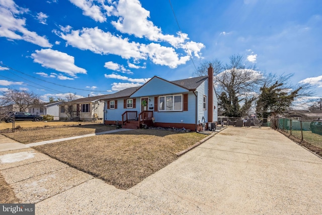 view of front of property with driveway, a shingled roof, a chimney, and fence