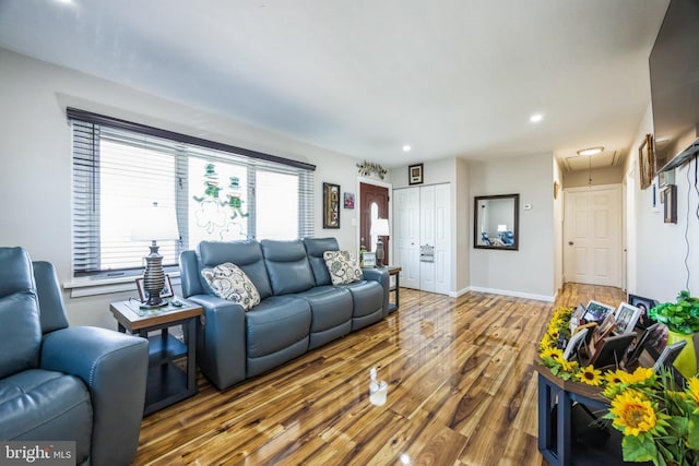 living area with recessed lighting, attic access, baseboards, and wood finished floors