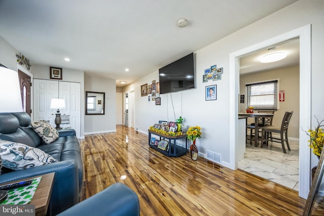 living area featuring recessed lighting, visible vents, marble finish floor, and baseboards