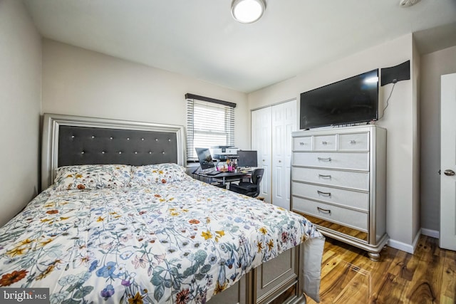 bedroom featuring a closet, baseboards, and wood finished floors