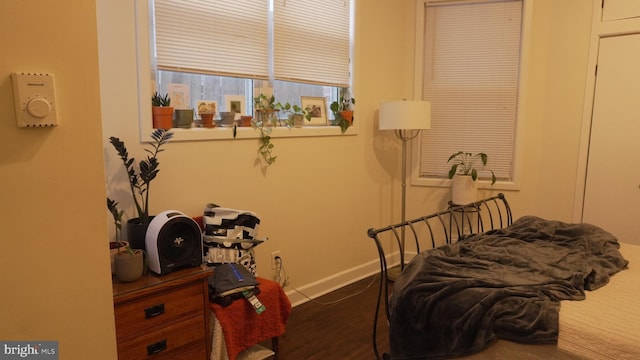 bedroom with baseboards and wood finished floors