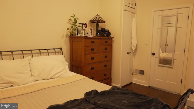 bedroom with visible vents and dark wood-style flooring