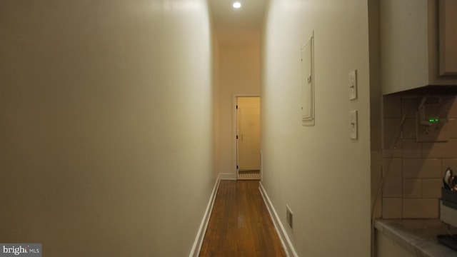 hallway featuring electric panel, dark wood-style floors, and baseboards