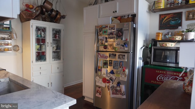 kitchen with white cabinetry, dark wood-type flooring, appliances with stainless steel finishes, and a sink