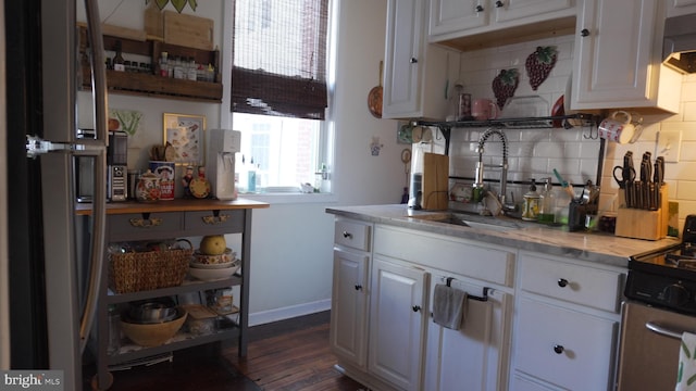 kitchen featuring a sink, backsplash, dark wood-style floors, white cabinets, and range