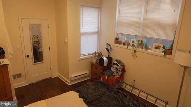 foyer with a baseboard radiator, baseboards, dark wood-type flooring, and visible vents