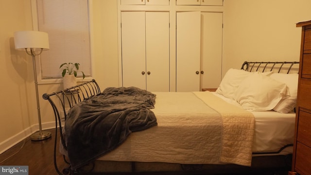 bedroom with a closet, baseboards, and dark wood-style flooring