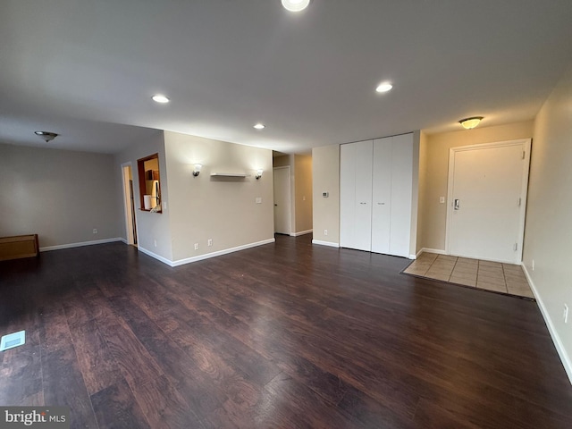 unfurnished living room with recessed lighting, wood finished floors, and baseboards