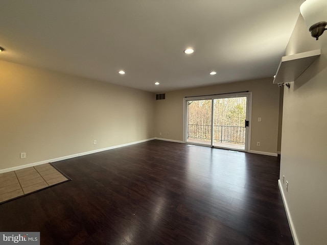 spare room featuring dark wood-type flooring, recessed lighting, baseboards, and visible vents