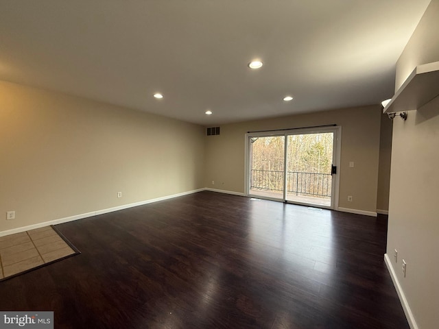 unfurnished room with visible vents, recessed lighting, baseboards, and dark wood-style flooring