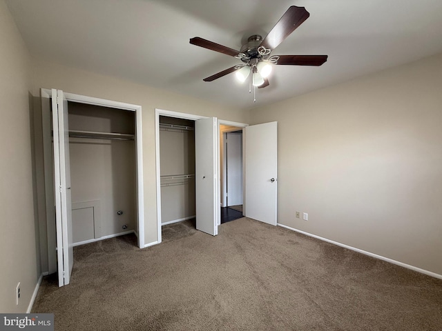 unfurnished bedroom featuring a ceiling fan, carpet, multiple closets, and baseboards