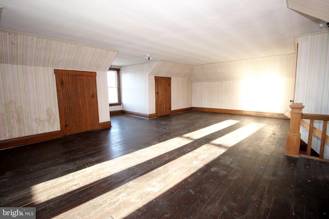 bonus room featuring baseboards and wood-type flooring