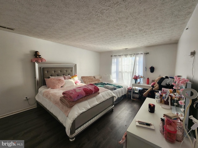 bedroom with visible vents, dark wood-style flooring, and a textured ceiling