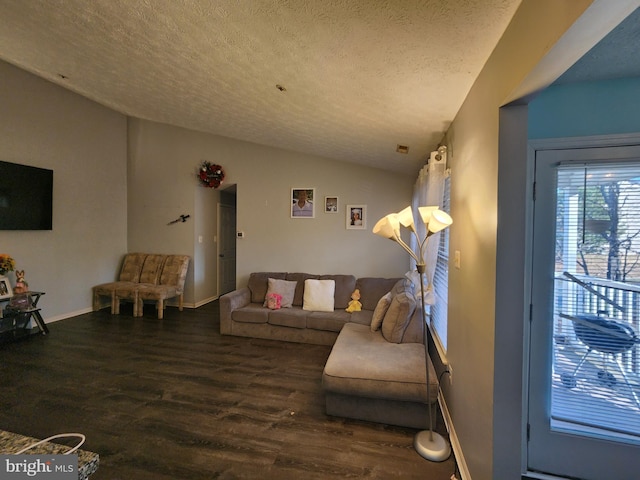 living area featuring baseboards, a textured ceiling, lofted ceiling, and wood finished floors