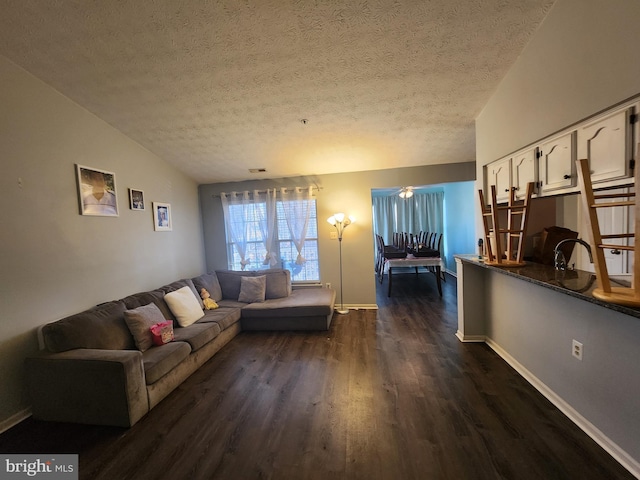 living room featuring baseboards, a textured ceiling, lofted ceiling, and dark wood finished floors