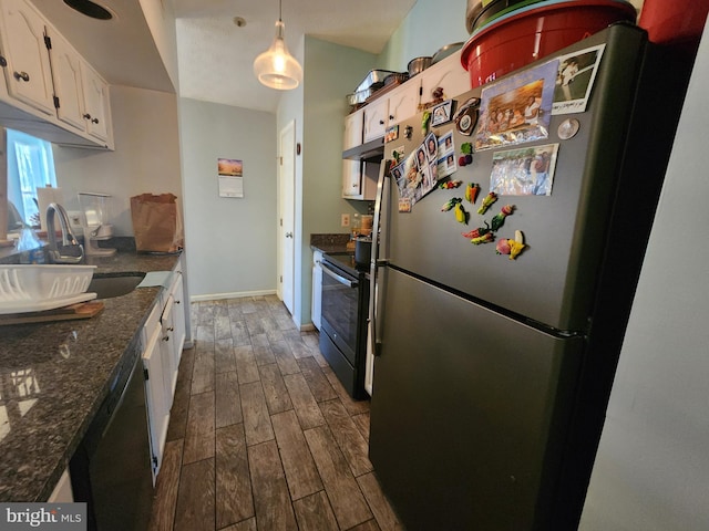 kitchen featuring baseboards, wood tiled floor, a sink, appliances with stainless steel finishes, and white cabinetry