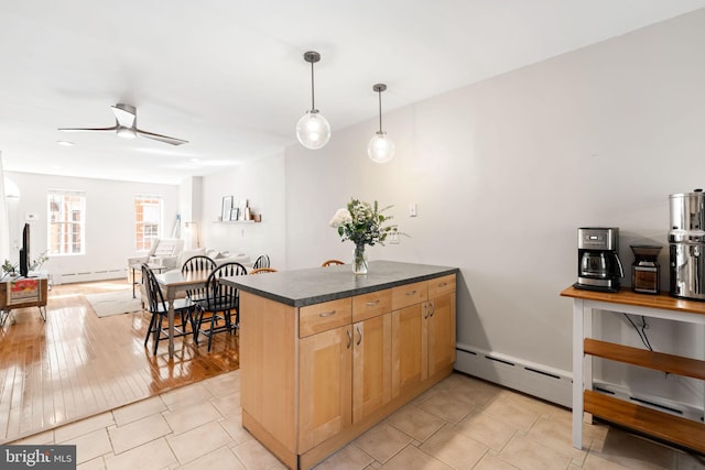 kitchen featuring dark countertops, ceiling fan, pendant lighting, a peninsula, and a baseboard radiator