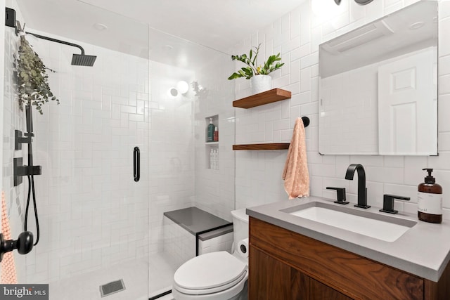 bathroom featuring vanity, a shower stall, tile walls, toilet, and backsplash