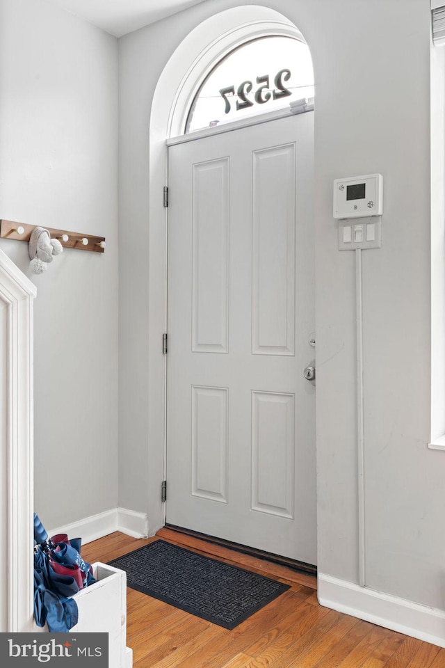 foyer featuring baseboards and wood finished floors