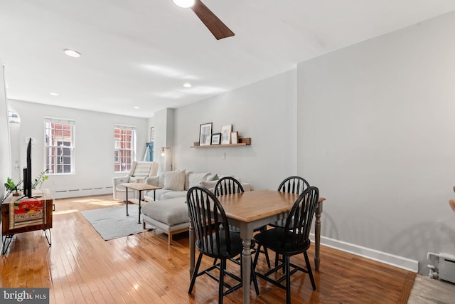 dining space featuring baseboards, recessed lighting, hardwood / wood-style flooring, a ceiling fan, and a baseboard radiator