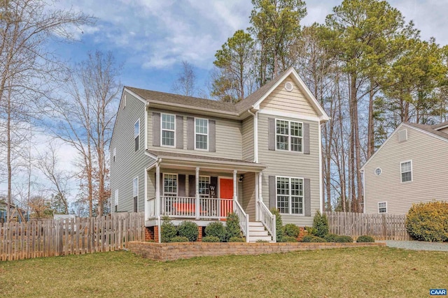 traditional-style house featuring a front yard, fence, and covered porch