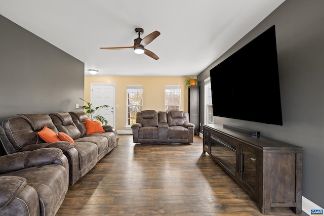 living area with dark wood-style floors, baseboards, and a ceiling fan