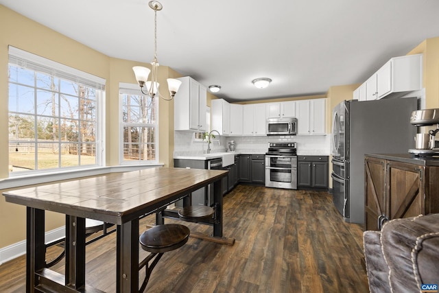 kitchen with backsplash, dark wood-type flooring, light countertops, stainless steel appliances, and white cabinetry