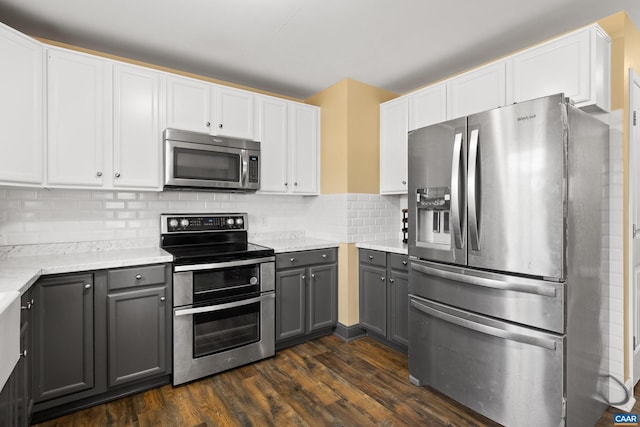 kitchen featuring dark wood finished floors, tasteful backsplash, appliances with stainless steel finishes, and gray cabinetry