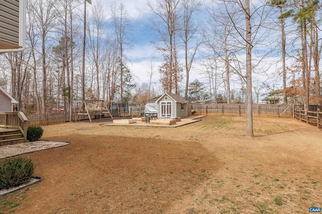 view of yard with a wooden deck, a fenced backyard, a storage shed, and an outdoor structure