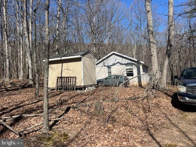 view of property exterior featuring a storage shed and an outbuilding