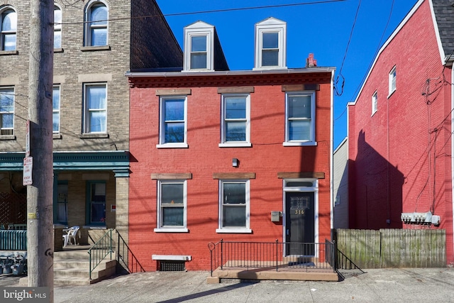 multi unit property featuring brick siding and fence