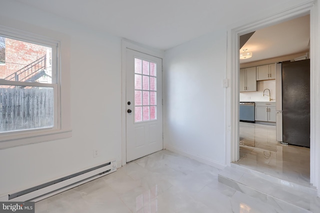 doorway to outside with a sink, a baseboard heating unit, and baseboards