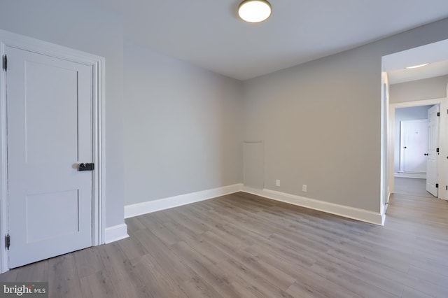 spare room featuring baseboards and wood finished floors