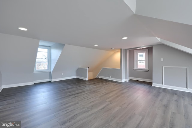 additional living space featuring a wealth of natural light, lofted ceiling, and dark wood-style floors