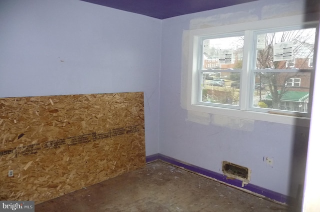 spare room with plenty of natural light and concrete flooring