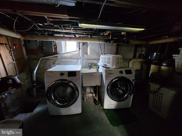 clothes washing area with washing machine and clothes dryer, laundry area, and a sink