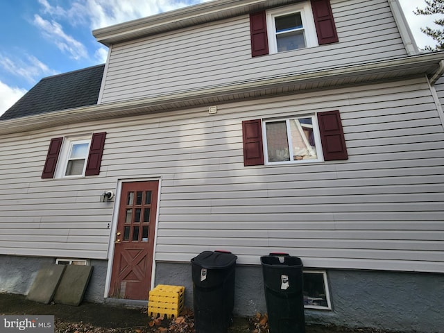 back of property featuring a shingled roof