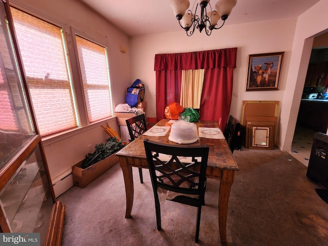 carpeted dining room featuring a baseboard heating unit and a chandelier