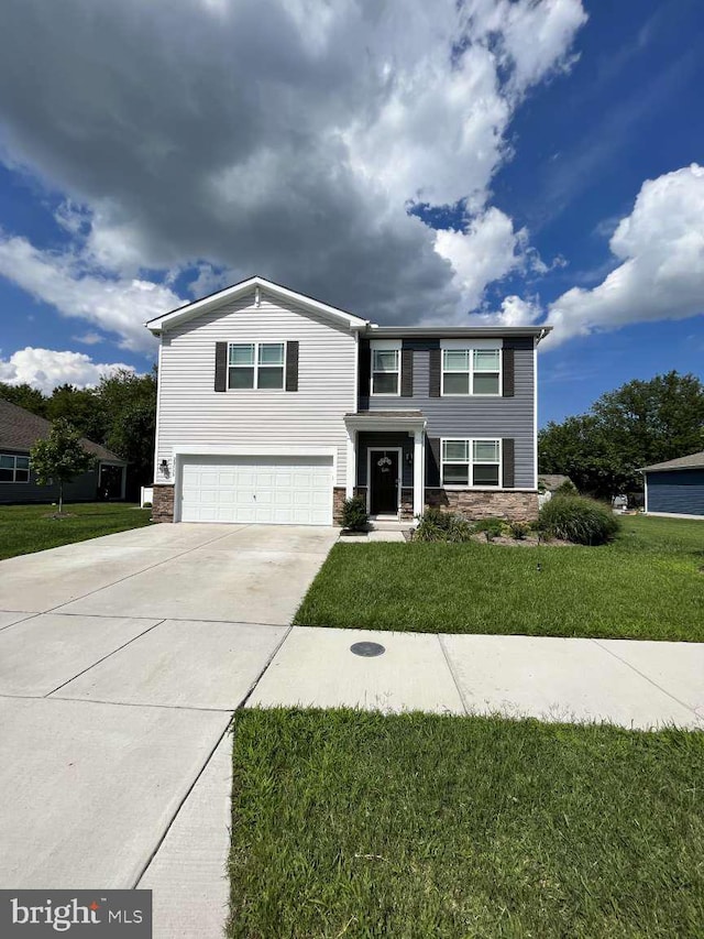 view of front of property featuring stone siding, concrete driveway, a garage, and a front yard