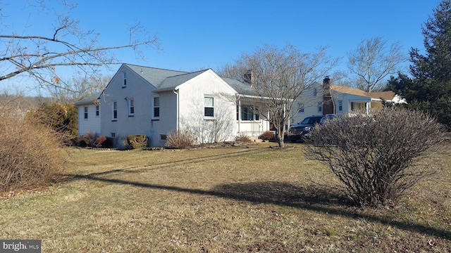 view of side of home featuring stucco siding and a lawn