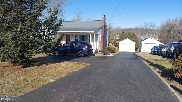 view of front of property with a garage, an outbuilding, and a chimney