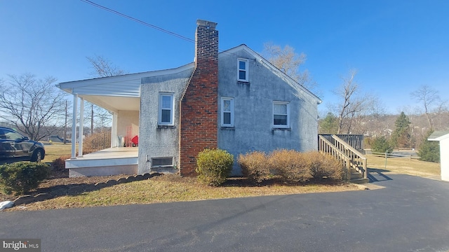 view of property exterior featuring stucco siding and a chimney