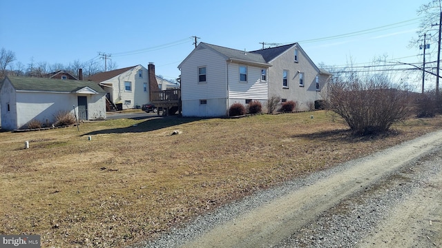 view of side of home with a yard